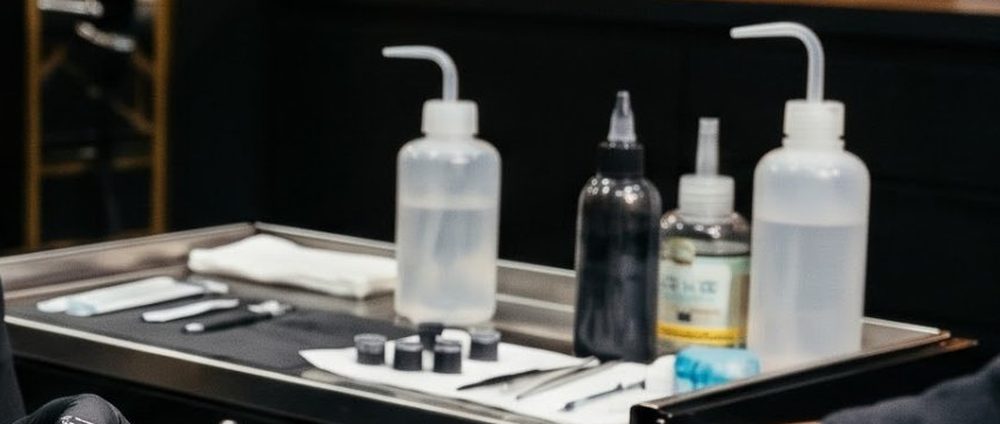 Bancada de trabalho preparada com tintas, frascos e material esterilizado